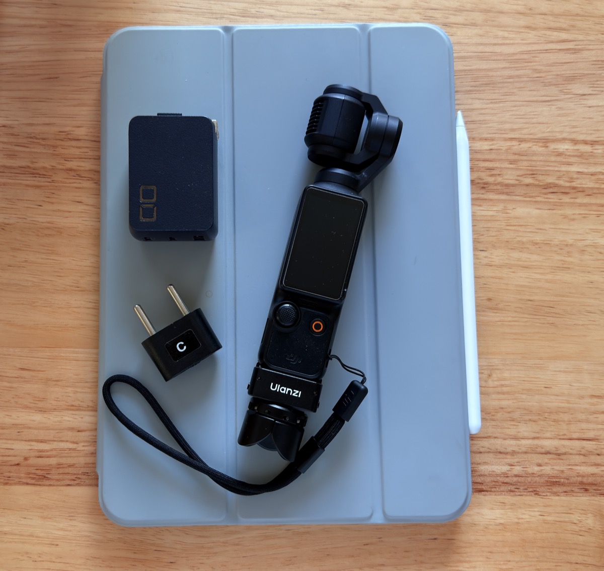 iPadの上に置かれた変換プラグ、USB急速充電器、DJI Osmo Pocket 3