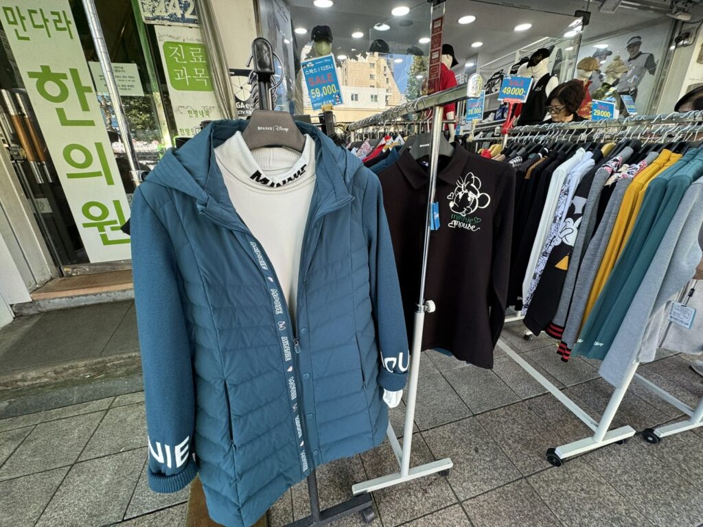 路上の服のラック。値札が並ぶ