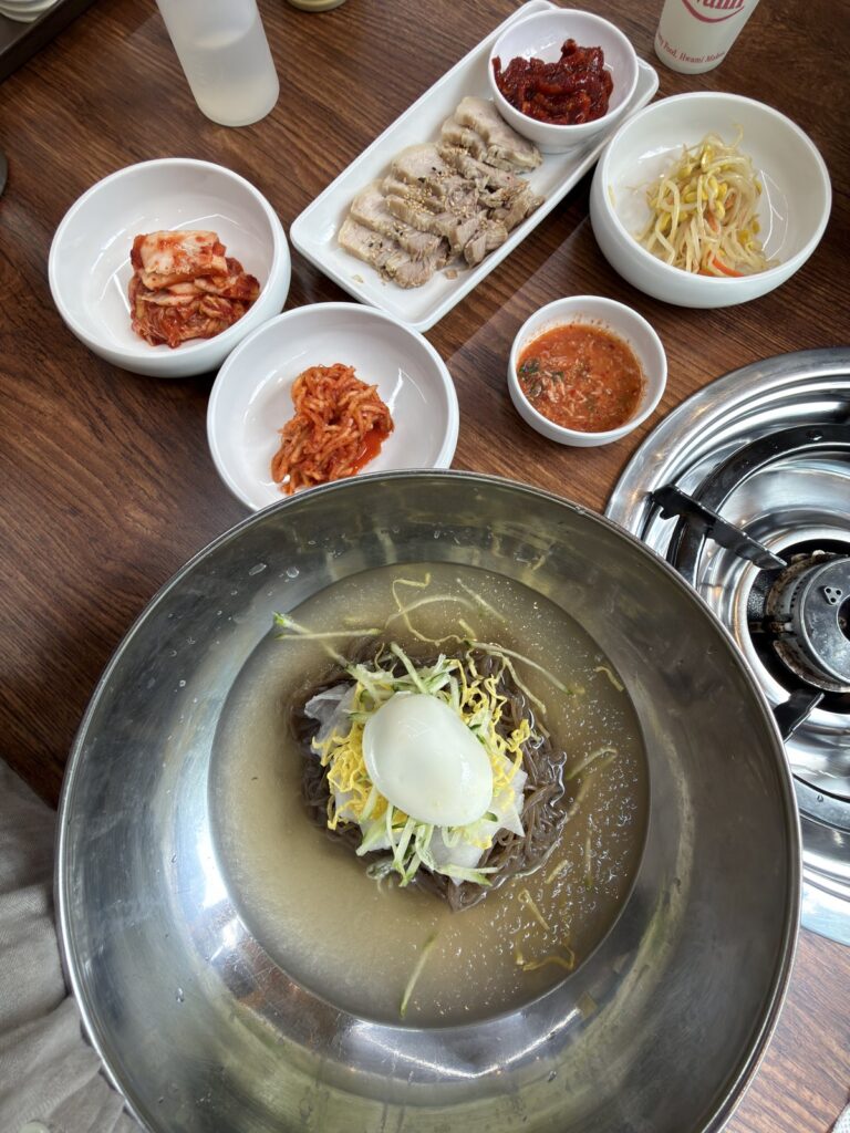 冷麺と小皿のおかずが並んだテーブル